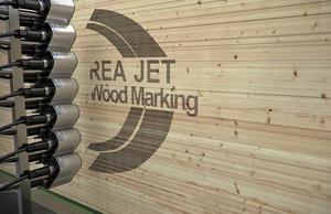 Großlogodruck auf Bretterstapel - REA JET DOD Großlogodruck auf Bretterstapel - REA JET DOD